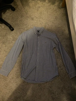 Blårutig skjorta från Ralph Lauren - Klassisk blårutig skjorta från Ralph Lauren med button-down krage och broderad logga på bröstet. Skjortan har lång ärm och är tillverkad i mjuk bomull. Perfekt för en stilren och avslappnad look.