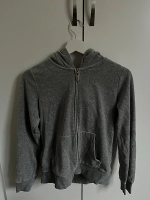 Grå zip hoodie med huva - En enkel och skön grå hoodie med dragkedja framtill och två fickor. Har även byxorna till denna så priset nedan är för hela settet inte separat. 