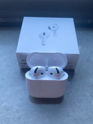 Apple AirPods Pro trådlösa hörlurar - Säljer ett par vita Apple AirPods Pro med laddningsetui. Hörlurarna har en stilren och kompakt design med silikonproppar och touchkontroller. Perfekta för dig som vill ha brusreducering och grymt ljud i ett smidigt format.
