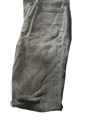 Svarta raka jeans - Säljer ett par svarta jeans med rak passform och klassisk femficksdesign. Jeansen har diskreta sömmar och är tillverkade i denim. Perfekta för en stilren och enkel look.