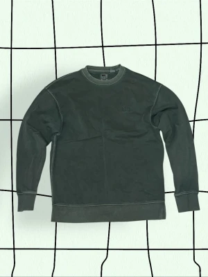 Levi’s tröja - Mörkgrön sweatshirt från Levi’s med rund halsringning och diskret logga broderad på bröstet. Perfekt för en avslappnad och stilren look. Storlek S.