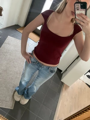 Vinröd linnetopp från Brandy Melville - Säljer en vinröd linnetopp från Brandy Melville med breda axelband och mjuk, stretchig känsla. Toppen är ärmlös och har en snygg, enkel design som är lätt att matcha. Materialet är bomull och bara använd några gånger men knappt 💞