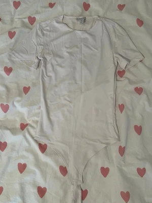 Vit kortärmad body från Amisu - Säljer en vit body från Amisu. Den kom inte till mycket användning eftersom att jag inte vet hur man stylar bodys, men jag hoppas att någon annan kan använda den💕Om du har frågor så är det bara att fråga på🫶🏼