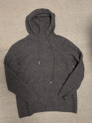 Mörkgrå kashmir-hoodie - Snygg mörkgrå hoodie i hundra-procent kashmirull. Använd endast ett fåtal gånger. Säljer då jag växt ur produkten. Skriv om ni har några funderingar, pris kan diskuteras!
