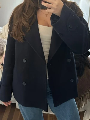 Marinblå kappa  - Stilren marinblå kappa med dubbelknäppning,  fyra knappar framtill. Använd endast fåtal gånger. Storlek S från Nelly💙💙