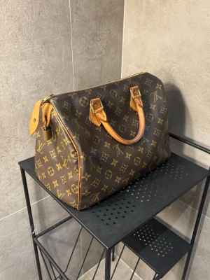 Louis Vuitton Speedy 30 - Louis Vuitton Speedy handväska med det klassiska monogramet. Size 30 (den är 30 cm bred). Väldigt fint skick. En grej som släppt på insidan (bild 7) men det påverkar ingenting och syns inte. Sjävklart äkta. Skriv för fler bilder eller vid funderingar!