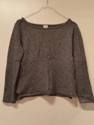 Mörkgrå stickad tröja Esprit - Mysig mörkgrå stickad tröja från Esprit med rund halsringning och långa ärmar. Tröjan har en enkel, rak passform och är tillverkad i ett mjukt material som passar perfekt för kyligare dagar.