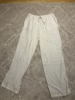 Vita linnebyxor från Ginatricot - Vita linnebyxor från Gina. De är väldigt mjuka tyget. Har fickor och knyte i midjan. Bra passform och bra i längden. Perfekt till sommaren. Bara använt någon enstaka gång är tyvärr för små för mig.