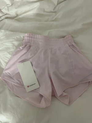 Hotty hot shorts från Lululemon - Snygga ljusrosa träningsshorts från Lululemon. Nästan aldrig andvända och säljer pga. Att de är för små, nypris:740kr