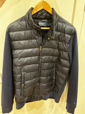 Cardigan, Polo Ralph Lauren - Cardiganjacka från Polo Ralph Lauren med blå vadderad framsida och marinblå ärmar i mjukt tyg. Perfekt nu inför våren och en stilig look