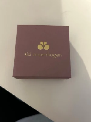 Sisi Copenhagen små silverringar - Säljer ett par stilrena små örhängen från Sisi Copenhagen. Örhängena är i form av tunna, runda ringar i silverfärg. Perfekta för dig som gillar minimalistisk och enkel design. Kommer i original ask.