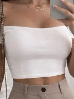 Vit croptop - Zara - Säljer en stilren vit crop top i mjukt material. Toppen är  croppad, perfekt för varma dagar eller som layering-piece. Enkel och clean design som passar till mycket.