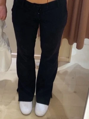 Svarta bootcut jeans - Säljer ett par svarta bootcut jeans med klassisk dragkedja och knapp framtill. Jeansen har en snygg passform som sitter tajt upptill och släpper ut mot benen. Perfekta till sneakers eller boots. Materialet känns mjukt och följsamt. Den saknar dragare för dragkedjan dok.