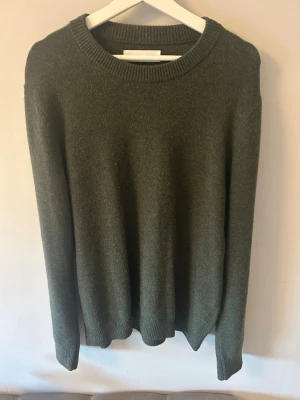 Mörkgrön stickad tröja Samsøe Samsøe - Mörkgrön stickad tröja från Samsøe Samsøe med rund halsringning och ribbade muddar vid ärmslut och nederkant. Ordinarie priset på tröjan ligger på 1495kr och den är gjord 100% av Ull. Jag kan lägga till ytterligare bilder vid behov, DM är öppen vid intresse.