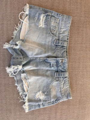 Ljusblå slitna jeansshorts - Säljer ett par ljusblå jeansshorts med fransiga kanter och slitna detaljer från Gina. Använda några få gånger och i bra skick. Nypris 299 kr. Storlek: S. Midjemått tvärs över: 41 cm. Skicka ett meddelande om du har några frågor💕