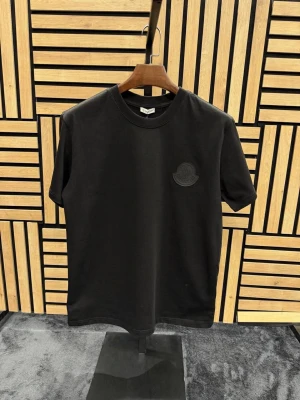 Märkeskläder  - Cool svart t-shirt från Off-White med en stor färgglad Mickey Mouse-print på ryggen och Off-White-logga i blått. Framsidan har en diskret svart patch på bröstet. T-shirten har rund hals och korta ärmar, perfekt för en streetwear-look.