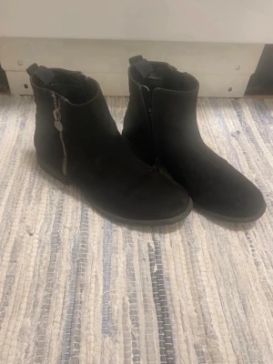 Svarta boots från Alley strl 38 - Ett par svarta boots från märket Alley. Köpte de för att jag tyckte att de kändes bra vid provning trots att jag har storlek 39 men märkte efter en promenad att de är för små så är bättre att de kommer till någon som har storlek 38.  De har lite slitage vilket kan ses på bilderna. Katt och hund finns i hemmet.   Storlek: 38 Märke: Alley