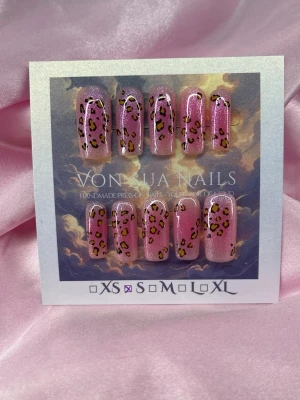 PinkLeo (S);Medium Square - Snygga handgjorda press-on naglar i storlek S: 15 mm, 11,5 mm, 12 mm, 11 mm, 9 mm . Naglarna är rosa med glitter och har ett trendigt leopardmönster i svart och gult. Formen är medium square, vilket ger en modern look. Perfekt för dig som vill sticka ut med coola detaljer.
