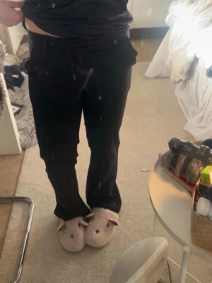 Svarta utsvängda mjukisbyxor - Säljer ett par svarta mjukisbyxor med utsvängda ben och hög midja. Byxorna har en enkel och clean look utan synliga loggor eller detaljer. Perfekta för chill dagar hemma eller när du vill vara bekväm men ändå se snygg ut.