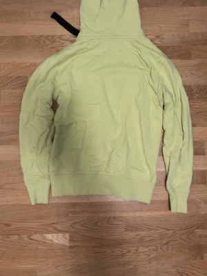 Ljusgul hoodie med svart snöre - Säljer en ljusgul hoodie med svart snöre i huvan och en liten ficka med knapp på bröstet. Hoodien har ribbade muddar vid ärmslut och nederkant. Perfekt för dig som gillar en chill och enkel stil. Calvin klein ordinarie pris: 1399. Kontakta mig för att prata mer om pris