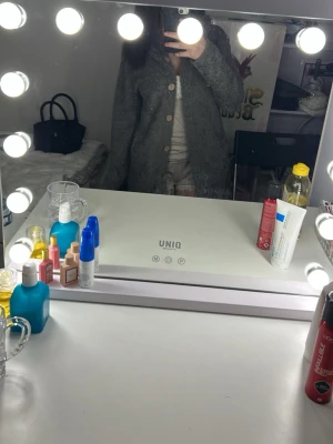 Grå lång ullkappa med knappar - Snygg grå lång kappa i ullmix med stora knappar framtill. Klassisk rak passform och långärmad design som passar perfekt till höst och vinter. Enkel och stilren look som funkar till många outfits.