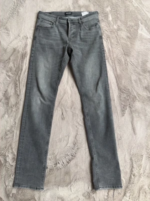 Grå slim fit jeans från Jack&Jones - Säljer ett par grå slim fit jeans från Jack@Jones storlek 32/34 modell Glenn