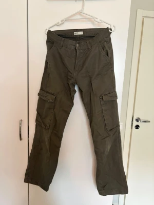 Gina tricot cargo jeans - Mörkgröna cargo jeans från ginatricot med låg midja. Syns lite slitage på knäna men annars fint skick. 🌷
