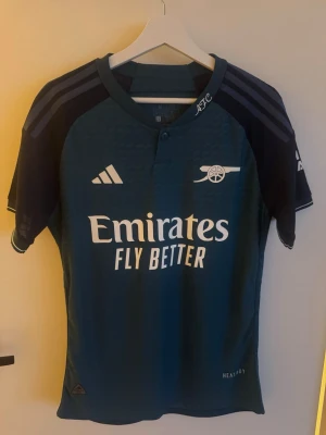 Arsenal Tredjeställ 23/24 - Självt aldrig använt men köpt här på plick, vet inte om den är äkta men den har samma kvalité ändå. Storlek M men passar nog bäst för S!
