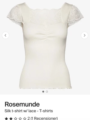 Vit ribbad spetsblus från Rosemunde - Supersöt HELT NY vit ribbad topp från Rosemunde med spetsdetaljer vid halsringningen och ärmarna. Kortärmad modell med lätt rynkning framtill och stretchigt material i silke och bomull. Perfekt för en romantisk look och enkel att styla till olika outfits. skriv för mer frågor eller bilder