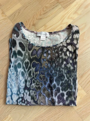 Leopardmönstrad långärmad topp - En långärmad topp med leopardmönster i flera färger som blå, grön, brun och svart. Toppen har rund halsringning och är tillverkad i ett mjukt, stretchigt material som känns skönt mot huden. Perfekt för dig som gillar djurmönstrat och vill sticka ut.