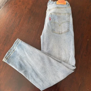 Levis jeans - Klassiska Levis 501 jeans i ljusblå denim med raka ben och femficksmodell. Byxorna har normal passform, knappgylf och Levis ikoniska läderpatch bak i midjan. Perfekta för en avslappnad stil. Storleken är 176cm (se bild 5). Jeansen är Loose taper och jag säljer dem för att jag har växt ur dem. Skick: 8/10. Pris går att diskuteras vid snabb köp!