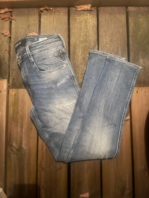 Replay ljusblå slim fit jeans - Snygga ljusblå jeans från Replay med slim fit passform och klassisk femficksdesign. Jeansen har slitningar och tvättade detaljer för en trendig look. Tillverkade i bomull med en liten mängd stretch för extra komfort.