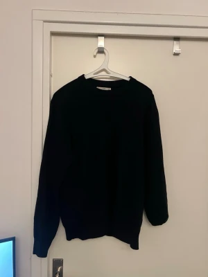 Svart stickad tröja från MNG Man - Klassisk svart stickad tröja från MNG Man med rund halsringning och ribbade muddar vid ärmslut och nederkant. Perfekt basplagg som funkar till det mesta och är enkel att matcha. Tillverkad i mjukt material för skön känsla.