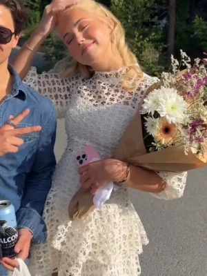 Vit spetsklänning med volang - Säljer en vit kortklänning med spetsmönster och volangdetaljer. Klänningen har en hög hals, korta ärmar och är tillverkad i ett luftigt material som passar perfekt för sommarens tillfällen. Den har en feminin och elegant form med v-ringad rygg och fina broderade detaljer.