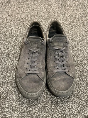 Garment Project Män Låg sneaker - Stilrena mörkgrå sneakers i mocka – 399 kr  Säljer ett par stilrena Garment Project sneakers i mjuk mocka med matchande mörkgrå snörning och sula. Klassisk låg modell med minimalistisk och clean design – perfekt för dig som gillar enkel och modern stil.  🖤 Färg: Mörkgrå 👟 Storlek: 43 📌 Heeldrag samt lite missfärgningar på mockan (se bilder) 🧦 Innersula medföljer ej – du behöver fixa ny sula själv  💡 Nypris: ca 1 800–2 000 kr för liknande modell (suede/låg sneaker från Garment Project) enligt åte