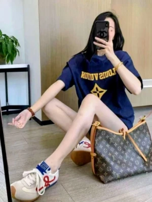 Iouis Vuitton T-shirt  - Mörkblå t-shirt i bomull med gult tryck. Framsidan pryds av en centrerad logotyp, och baksidan har ett större texttryck tillsammans med en grafisk blomstermodul. Tröjan har en klassisk passform med rund halsringning och korta ärmar.( Fast pris)