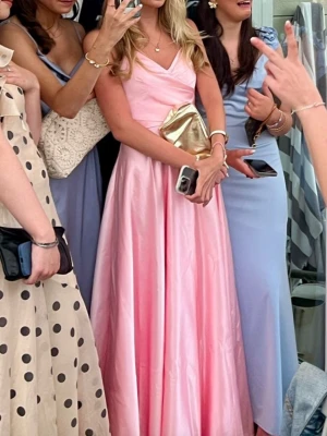 Lång rosa klänning med v-ringning - Säljer min gamla balklänning💕den är använd endast en gång och är i jättebra skick! Jag är 166 cm lång och storleken på klänningen är 