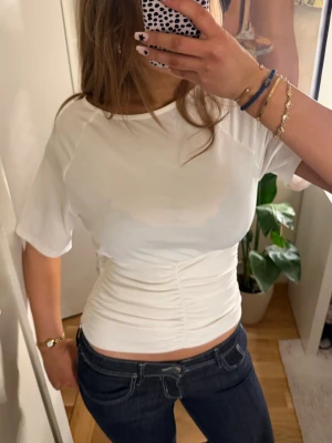 Vit figursydd topp - Säljer en vit topp med figurnära passform med dragkedja på sidan från Anna Field🥰Storlek S 