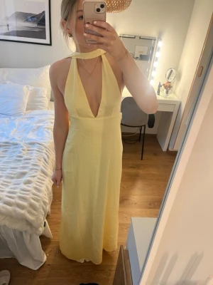 Alicia Satin Halter Maxi Dress - Gul satin balklänning - Superfin gul satin balklänning från Peppermayo (kolla hemsida för bättre bilder). Helt oanvänd, endast testad. Säljer pågrund av hittat annan balklänning. Har justerbart band i ryggen och dragkedja på sidan (se bild). Jag är 176 cm för referens! Pris kan diskuteras! (Nypris 1000 kr)