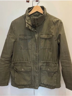 Parkajacka Samsøe Samsøe - Parkajacka i olivgrön färg från Samsøe Samsøe med hög krage. Perfekt snygg jacka inför hösten. Se bilder för skick. Jackan skickas samma dag eller dan efter. Hör gärna av dig om du har frågor eller funderingar.