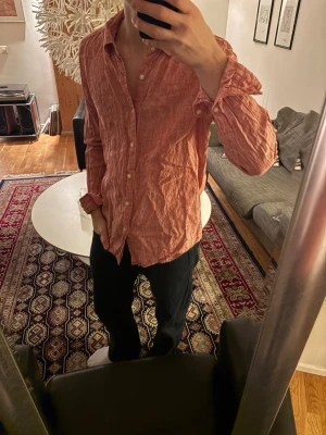linneskjorta  - Säljer en avslappnad korall/röd skjorta i linne med klassisk krage och knäppning framtill. 
