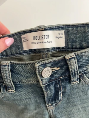Hollister ultra low-rise flare jeans  - TRYCK EJ PÅ KÖP NU! Skriv gärna innan så jag håller mig aktiv vid tillfället där du vill köpa jeansen! Tar emot bud! Säljer ett par blåa trendiga ultra low-rise flare jeans från Hollister. De har  femficksdesign, regular passform och snygg tvättad sopad look. Prislapp kvar och allt. Nya, oanvända. Skriv för fler bilder och information😁