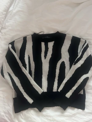 Svart och vit zebramönstrad stickad tröja - Stickad tröja i zebra mönster som är i väldigt bra skick! Hör av dig vid intresse eller fler bilder!