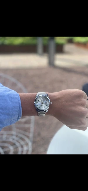 Silverfärgad klocka från Doventi  - Stilren klocka från Tissot i silver med metallarmband och rund urtavla. Urtavlan är ljus med tydliga markeringar och datumvisning. Klassisk design som passar till många olika outfits och ger en clean look.