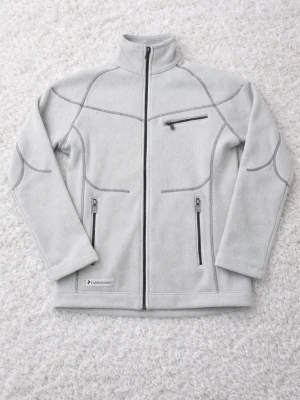 Ljusgrå fleecejacka Peak Performance - Snygg ljusgrå fleecejacka från Peak Performance med hög krage och hel dragkedja. Jackan har tre dragkedjeförsedda fickor och dekorativa sömmar. Perfekt för lager-på-lager och outdoor-looks. Känns som Small