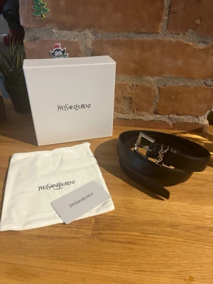 YSL Bälte - Yves saint Laurent bälte. Aldrig buret. 100cm. Allt på bilderna medföljer ink kort av äkthet. Skickas snabbt!