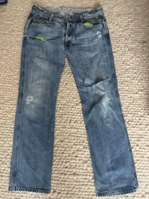 Blå slitna jeans med raka ben - W34 L32, men dem är lite mindre i midjan. Ett par feta ovanliga ljusblåa jeans från diesel, gröna fickor och sköna detaljer. ÄR ÖPPEN FÖR PRISFÖRSLAG!