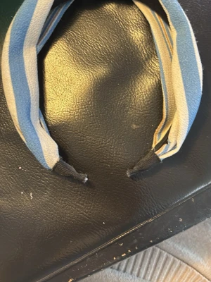 Randigt blått och vitt diadem - Säljer ett snyggt diadem med bred form och twistad knut framtill. Diademet har blå, vita och beige ränder i tyg med mjuk struktur. Perfekt för att ge en fräsch touch till din outfit.