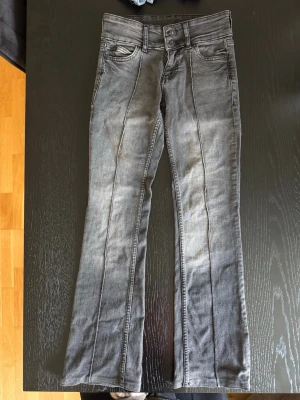 Grå snygga jeans från Bershka med pressveck - Jag säljer ett par coola jeans från Bershka i storlek 34. Jag har sytt upp dem så innerbenslängden är 74,5 cm lång. De är i mycket bra skick då de endast används några få gånger 🩷