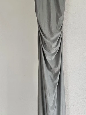 Silverfärgad balklänning med paljetter - Snygg balklänning i silver med smala axelband och glittrig paljettöverdel, sjöjungfrumodell. Helt ny, aldrig använd och köpt för ca 700kr. I storlek S. ❤️